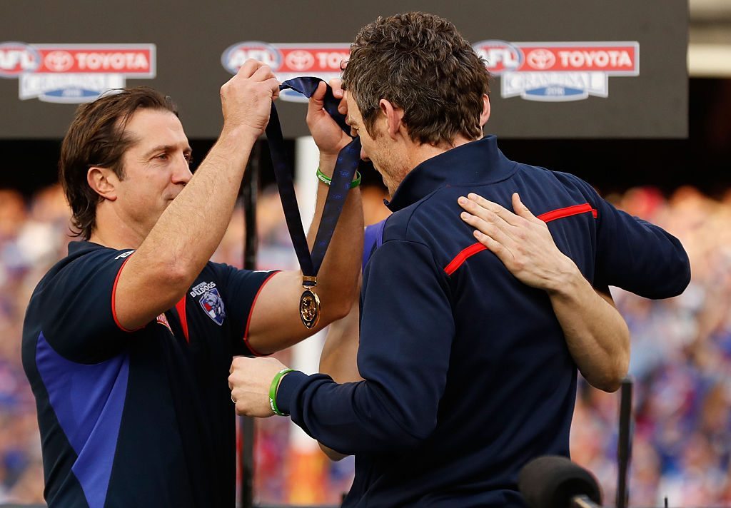 MELBOURNE, AUSTRALIA - OCTOBER 01: Luke Beveridge, Senior Coach of the Bulldogs and Easton Wood, Acting Captain of the Bulldogs present injured captain Robert Murphy with a premiership medal during the 2016 Toyota AFL Grand Final match between the Sydney Swans and the Western Bulldogs at the Melbourne Cricket Ground on October 01, 2016 in Melbourne, Australia. (Photo by Adam Trafford/AFL Media/Getty Images)